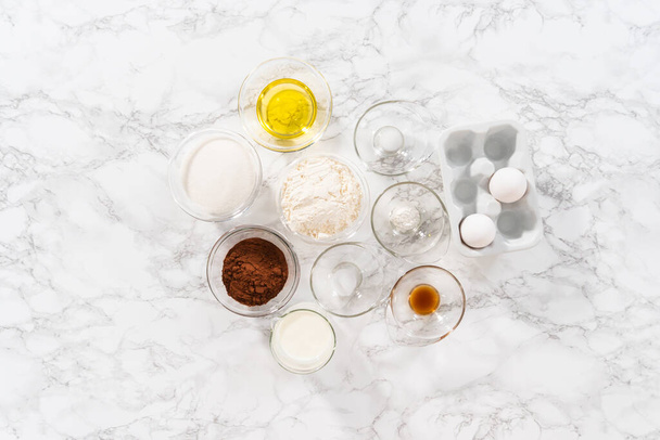 Flat lay. Measured ingredients in glass mixing bowls to prepare chocolate cupcake. - Fotoğraf, Görsel