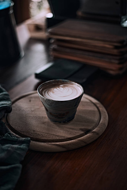 Copo de foco seletivo de café de arte de latte quente na mesa de madeira, foco no foa branco - Foto, Imagem