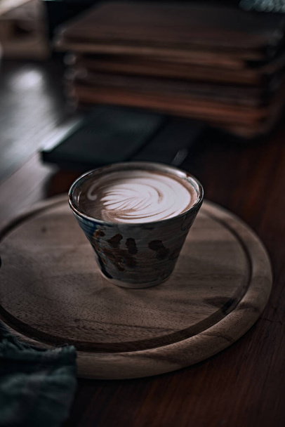 Selective focus cup of hot latte art coffee on wooden table,focus at white foa - Fotoğraf, Görsel