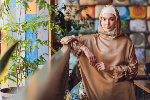 Arabian young muslim woman sitting in a cafe. - Foto, imagen