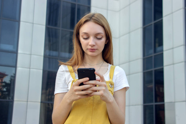 Das Mädchen tippt SMS. Teenager mit dem Handy. Jugend und Technologie. Kommunikation durch Korrespondenz - Foto, Bild