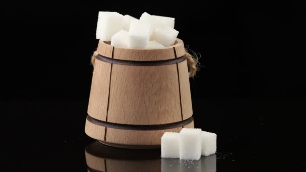 Veel stukjes witte suiker in een houten vat - Video
