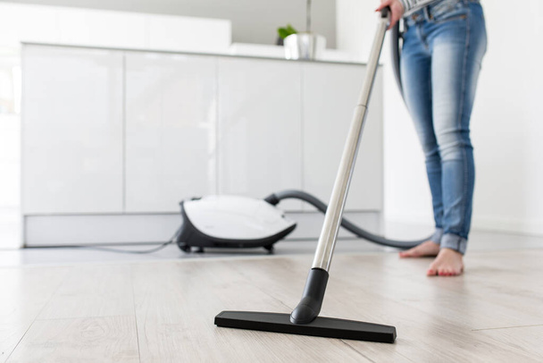 Woman using Vacuum Cleaner in Kitchen - Fotoğraf, Görsel
