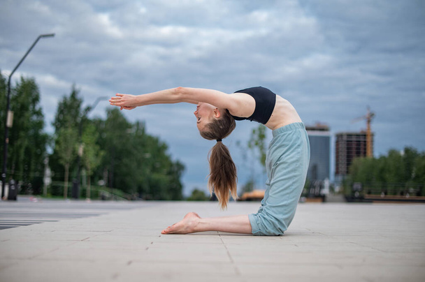 Chica practica yoga y meditación en la ciudad. - Foto, imagen