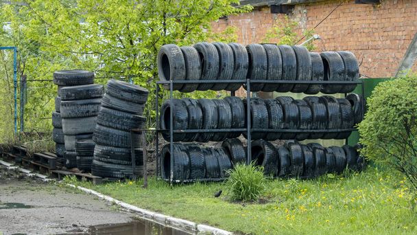 staré a mokré auto pneumatiky na polici v blízkosti autoservisu - Fotografie, Obrázek