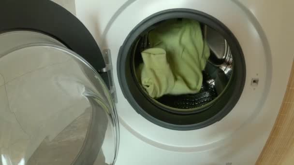 POV: Вид от первого лица на загрузку стиральной машины с грязными стиральными машинами и одеждой - Кадры, видео