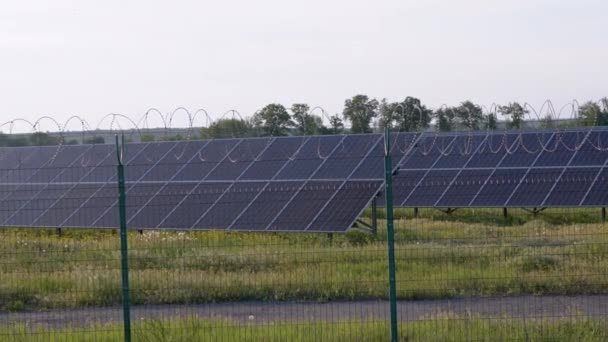 Sonnenkollektoren mit Stacheldrahtzaun eingezäunt. Solarbatterien. 4K - Filmmaterial, Video