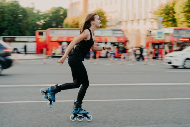 A mulher europeia em bons passeios de forma física em rolos de patins em patins em linha vestidos no desgaste ativo tem o resto ativo. Conceito de estilo de vida desportivo - Foto, Imagem