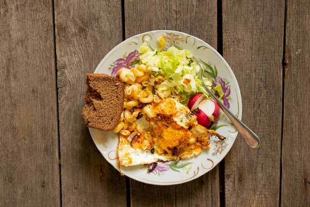 Spiegelkraut und Ridiska-Salat und ein Stück Schwarzbrot auf einem alten Holztisch in der Küche, hausgemachtes Essen - Foto, Bild