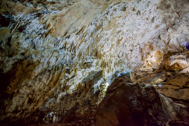 Jaskinia podziemna, niesamowita scena, widok na stalaktyty i stalagmit pod ziemią, formacja wewnątrz. - Zdjęcie, obraz