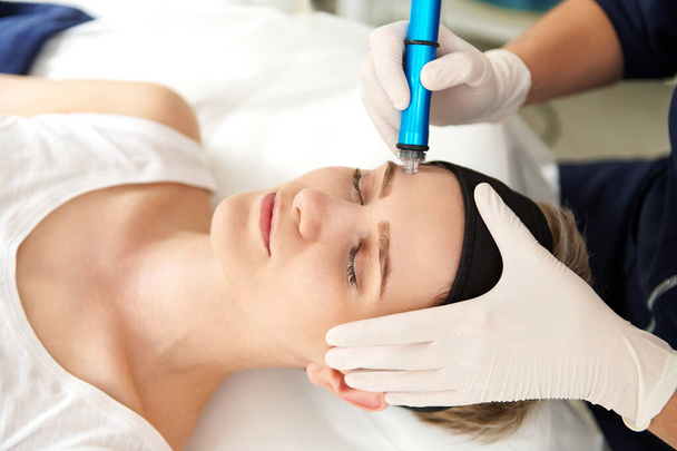 スパセンターで顔のハイドロマイクロダーマレーバー剥離治療を受ける女性。ヒドラ掃除機。剥離、若返りと水分補給。スキンケアコンセプト - 写真・画像