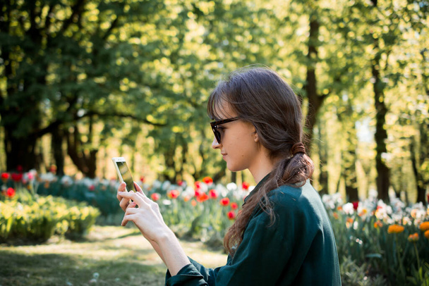 Beautiful young woman portrait in summer city park - Фото, изображение