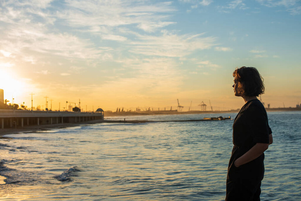Вид збоку жінки, яка дивиться на захід сонця
 - Фото, зображення