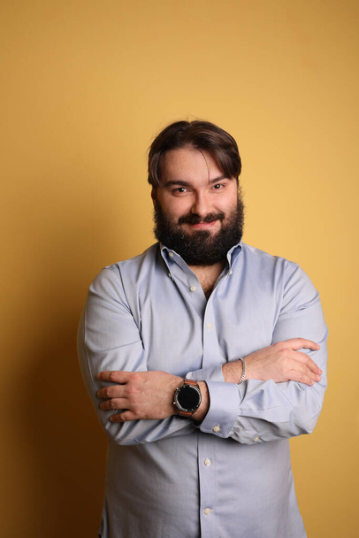 Happy big man with beard, posing over yellow background. Vertical. - Foto, immagini