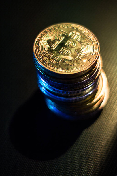 Stack of bitcoins over dark surface in neon lights - Zdjęcie, obraz