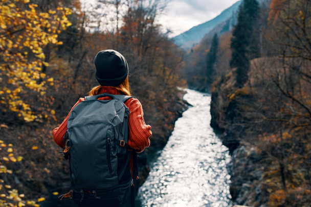 リュックを持つ女性観光客は自然川の山の旅を賞賛 - 写真・画像