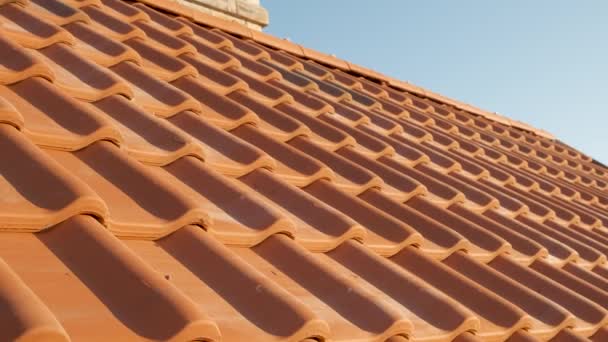 Overlappende rijen gele keramische dakpannen die het dak van een woongebouw bedekken. - Video