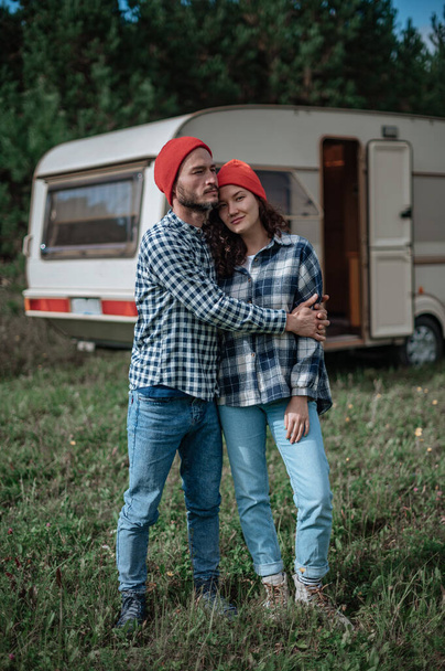 Romantisch stel brengt tijd samen door in de buurt van woonwagen. Samen met de camper reizen. - Foto, afbeelding