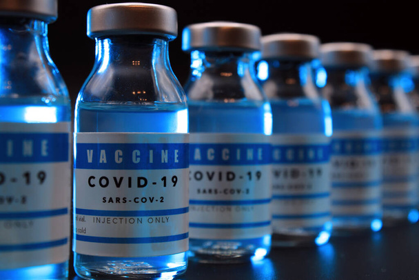 Φιαλίδια εμβολίου Covi- 19 παρατεταγμένα σε μαύρο φόντο - Φωτογραφία, εικόνα
