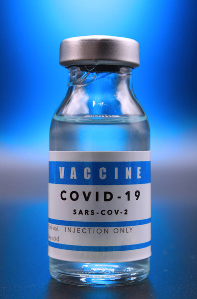 Covid-19 vakcina injekciós üveg kék vaku alatt - Fotó, kép