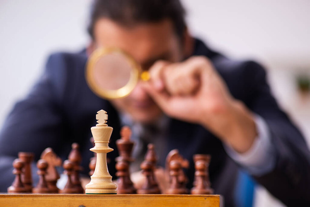 Young male employee playing chess at workplace - Photo, Image