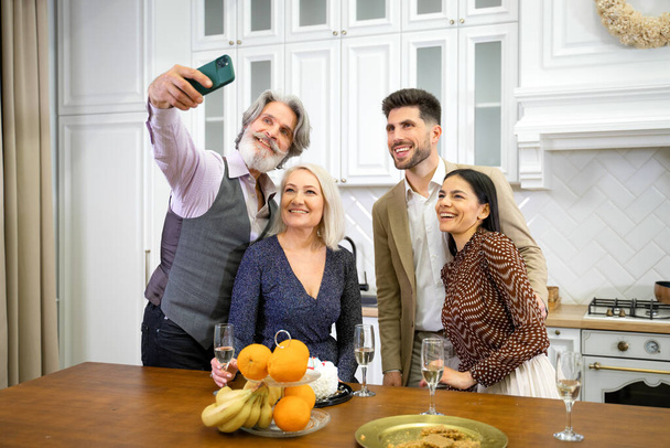 Glückliche Familie lächelt beim Selfie auf dem Smartphone bei Geburtstagsfeier - Foto, Bild