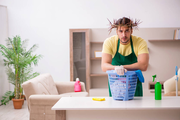 Young male contractor wearing prickly wreath on head cleaning th - Fotografie, Obrázek