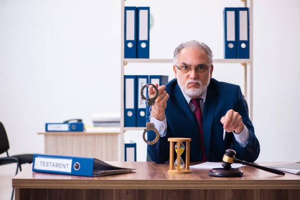 Досвідчений суддя чоловічої статі сидить в офісі
 - Фото, зображення