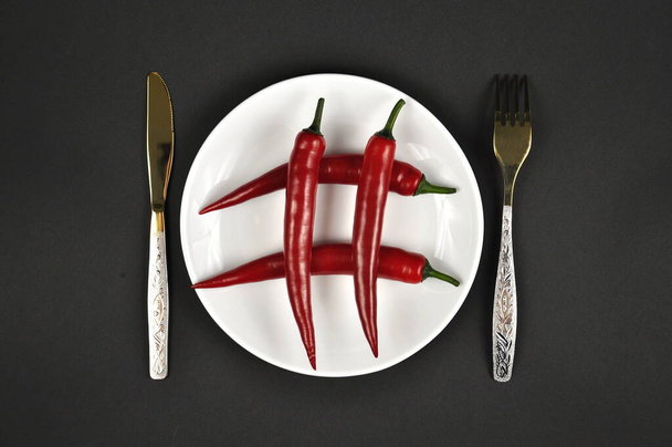 Hashtag. Red Chili peppers on a white plate. - Фото, изображение