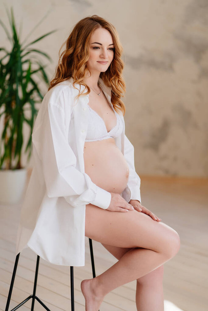 beautiful pregnant woman in white shirt. the beauty of the female body. - 写真・画像