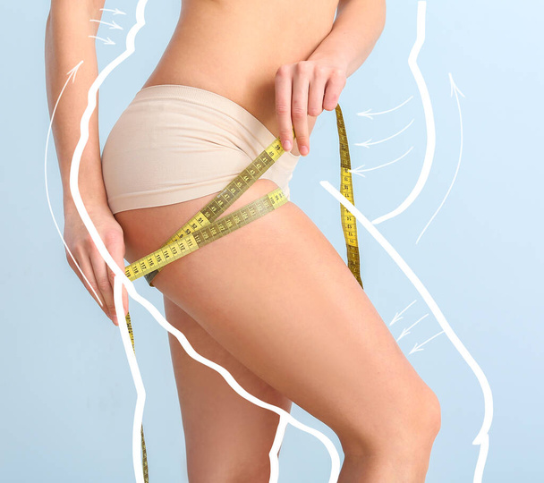 Young woman with measuring tape after weight loss on color background - Foto, afbeelding
