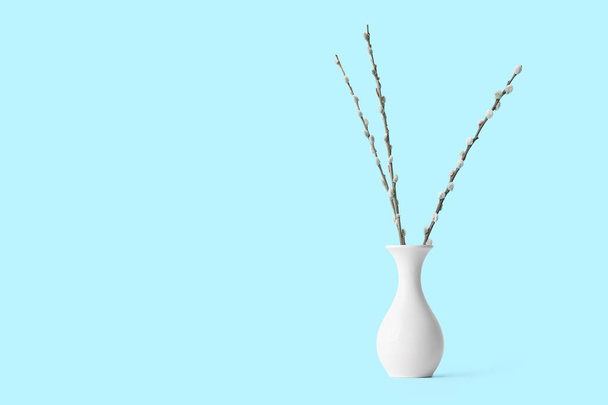 Vase with willow branches on color background - Foto, imagen