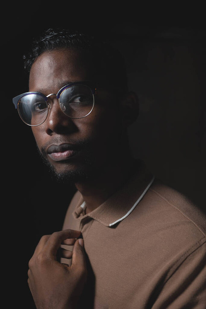 Jovem etnia negra com camisa de chocolate em um fundo preto - Foto, Imagem