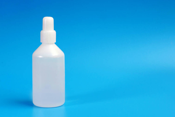 closeup of white plastic medicine bottle on blue background with a copy space - Φωτογραφία, εικόνα