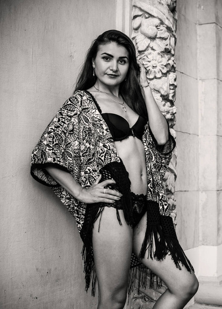 Araberin oder Zigeunerin mit langen Haaren demonstrierte ihren Körper. eine Frau mit schlanker Figur und athletischem Körper im Strickpullover, bekleidet mit einer sexy Strickjacke in Vintage-Tönen - Foto, Bild