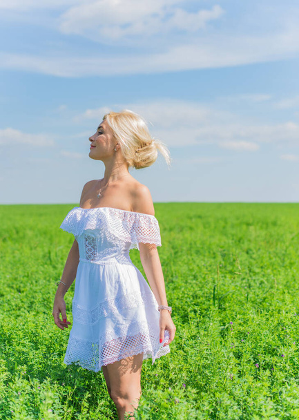 Conceito de liberdade, foto romântica da mulher no campo verde, sol da noite, beleza menina romântica em vestido branco ao ar livre. Luz do sol - Foto, Imagem