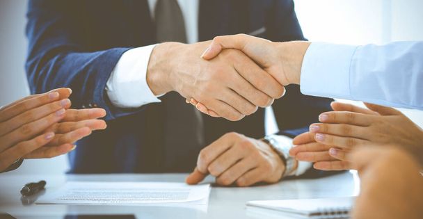Businesspeople or lawyers shaking hands finishing up a meeting in blue toned office , close-up. Success at negotiation and handshake concepts - Foto, Imagen