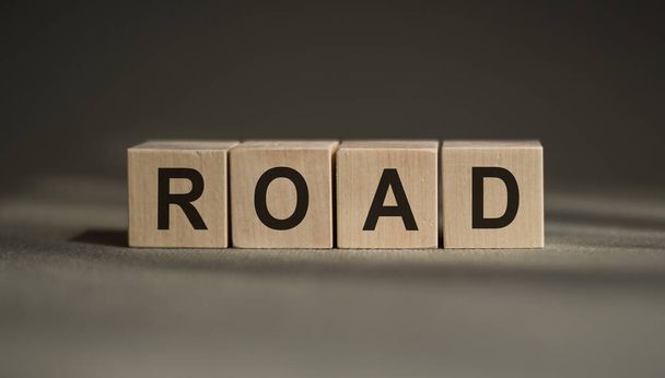 A wooden blocks with the word ROAD written on it on a gray background. - Φωτογραφία, εικόνα