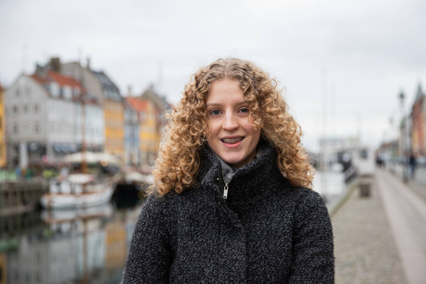 Посміхнена дівчина-підліток, вона носить фігурки, це зима і вона в Копенгагені. - Фото, зображення