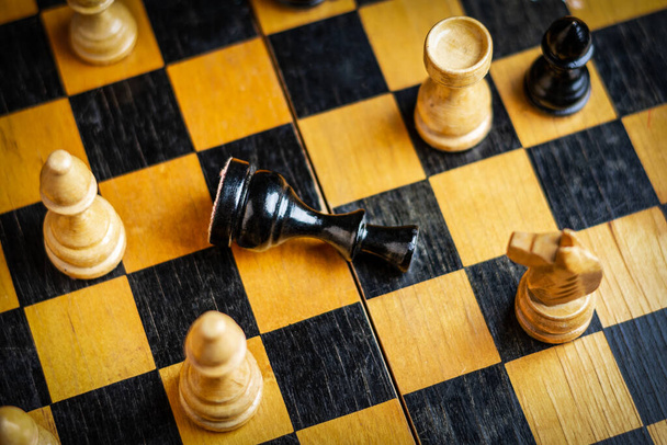 黒の王はチェス盤の上にある。選択的フォーカス。最上階だ。敗北だ。悪い戦略の概念。スポーツだ。事業. - 写真・画像