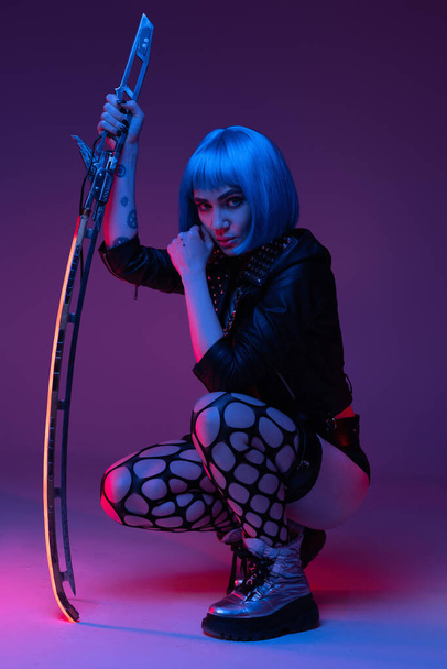 Martial cyberpunk hipster woman with sword inside studio - Foto, Imagen
