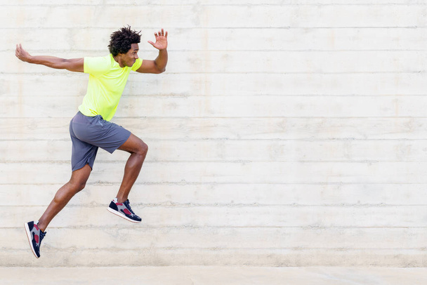 Black man training running jumps to strengthen his legs. - Fotó, kép
