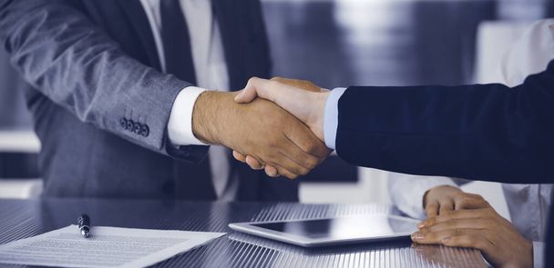 Handshake as successful negotiation ending, close-up. Unknown business people shaking hands after contract signing in modern office - Zdjęcie, obraz