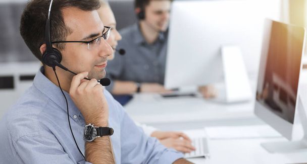 Call center. Group of casual dressed operators at work. Adult businessman in headset at customer service office. Telesales in business - Фото, зображення