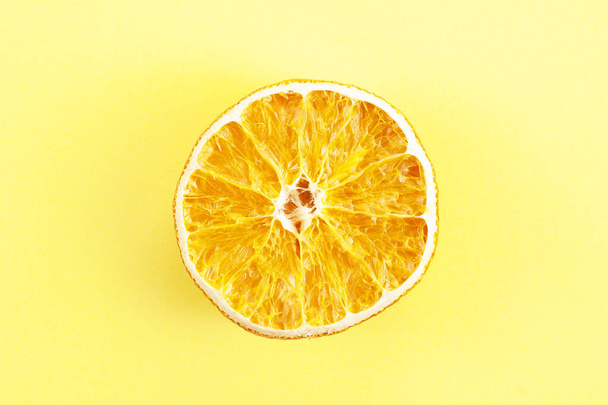 Um pedaço de laranja seca no fundo amarelo - Foto, Imagem