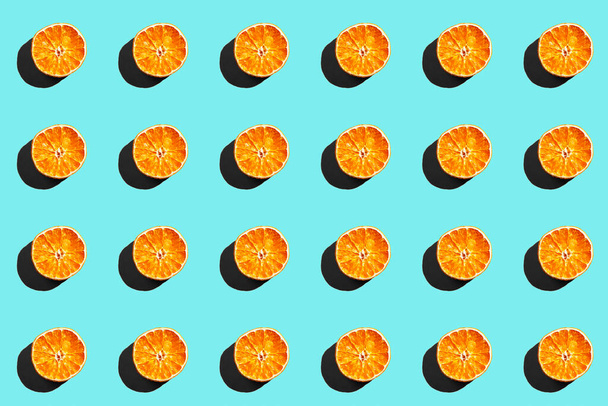 Patrón repetitivo hecho de naranja seca sobre fondo azul - Foto, imagen