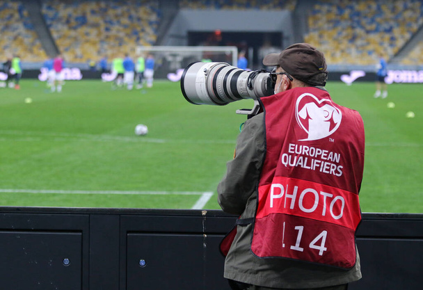 KYIV, UKRAINE - MARCH 28, 2021: Photographer at work seen during the FIFA World Cup 2022 Qualifying round game Ukraine v Finland at NSK Olimpiyskiy stadium in Kyiv, Ukraine - Photo, image