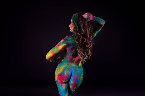 Bright colorful body art on black background, sexy nude woman painted with powder paints, studio shot - Photo, image