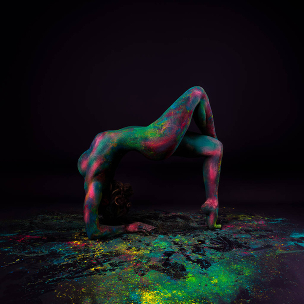 Arte corporal colorido brillante sobre fondo negro, mujer desnuda sexy flexible pintada con pinturas en polvo, toma de estudio - Foto, Imagen