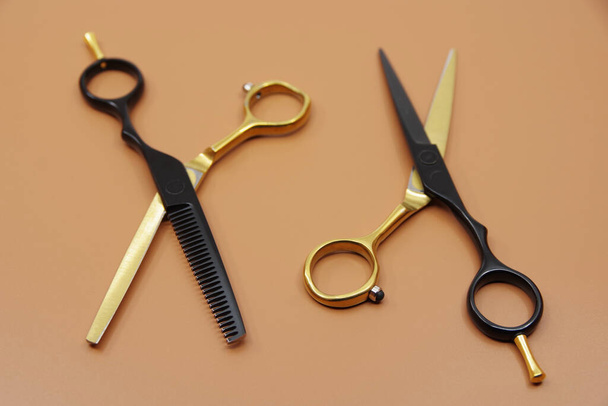 Професійні перукарські ножиці. Перукарські інструменти ізольовані на коричневому фоні
.  - Фото, зображення